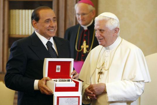FILE - In this Friday, June 6, 2008 file photo, Italian Premier Silvio Berlusconi shows one of the gifts he received from Pope Benedict XVI, a pen commemorating St. Peter, on the occasion of their meeting at the Vatican City. Premier Silvio Berl...