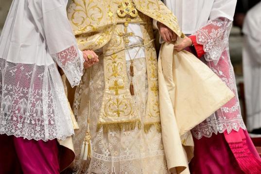 Pope Benedict XVI is helped by assistants as he celebrates the Vespers and Te Deum prayers in Saint Peter's Basilica at the Vatican on December 31, 2012.    AFP PHOTO / ANDREAS  SOLARO        (Photo credit should read ANDREAS SOLARO/AFP/Getty Images)