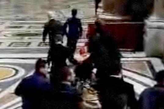 Grab taken from the Vatican TV shows French Cardinal Roger Etchegaray being carried away after getting injured as a woman threw herself at Pope Benedict XVI and dragged him to the ground as he entered St Peter's Basilica to celebrate Christmas E...