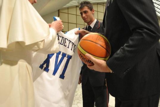 This handout picture released by The Vatican press office shows Pope Benedict XVI receiving a basketball jersey from former Italian basketball player Meneghin on December 16, 2009 after his weekly general audience at The Vatican. AFP PHOTO   RES...