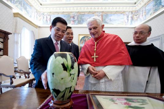Pope Benedict XVI looks at a gift offered by Vietnam's President Nguyen Minh Triet (L) during their meeting in his private library at the Vatican on December 11, 2009.   AFP PHOTO / CHRISTOPHE SIMON (Photo credit should read CHRISTOPHE SIMON/AFP...