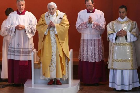 Pope Benedict XVI (2nd L) prays during a mass in a parish of 'Santa Maria del Rosario ai Martiri Portuensi' in the outskirts of Rome, 16 December 2007. AFP PHOTO / ALBERTO PIZZOLI (Photo credit should read ALBERTO PIZZOLI/AFP/Getty Images)