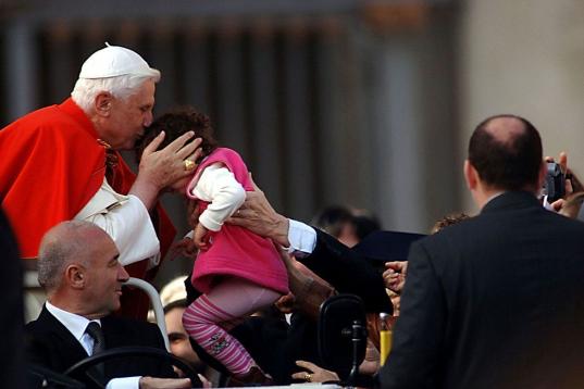 VATICAN CITY - DECEMBER 7: Pope Benedict XVI kisses a child as the faithful gather in St. Peter's Square as he arrives for his weekly audience on December 7, 2005 in Vatican City. According to news reports, details of the pontiff's first visit t...