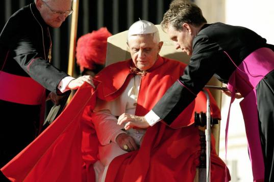 Vatican City, VATICAN CITY STATE:  Pope Benedict XVI is helped by his private secretary Georg Gaenswein (R) and bishop James Harvey prior his weekly general audience in St. Peter's Square at the Vatican 23 November 2005. The Vatican relaced 22 N...