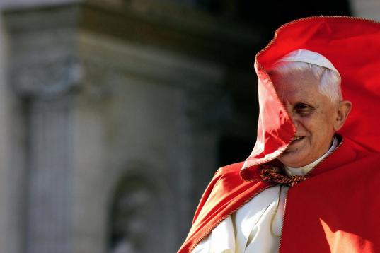 Vatican City, VATICAN CITY STATE:  Pope Benedict XVI smiles as the wind blows his red cape during his weekly general audience in St. Peter's Square at the Vatican 23 November 2005. The Vatican relaced 22 November a document reading that men with...
