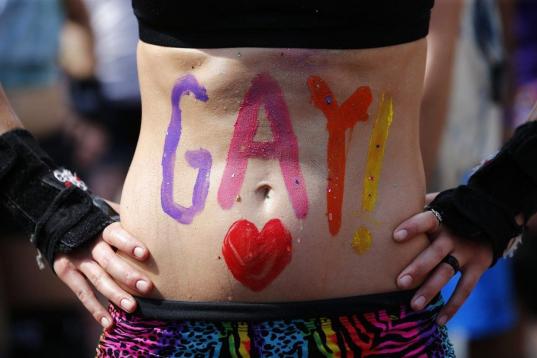 Una mujer enseña su vientre, con la palabra 'Gay' escrita en él, en Toronto (Canadá).