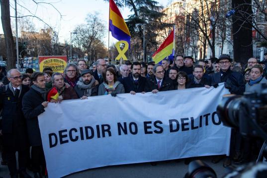 Los políticos independentistas, concentrados ante el Supremo tras la pancarta que dice: "Decidir no es delito". 