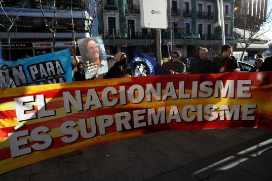 Un grupo de personas se concentra tras una bandera con la leyenda "El nacionalisme és supremacisme" ("El nacionalismo es supremacismo") ante el Supremo. 