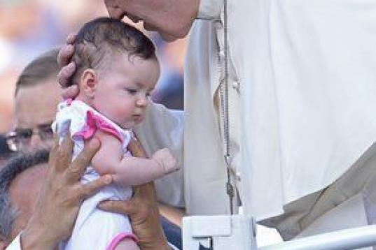 Pope Francis blesses a baby as he arrives for an audience with the participants at the Convention of Rome Diocese at St Peter's square on June 14, 2015 at the Vatican.  AFP PHOTO / FILIPPO MONTEFORTE        (Photo credit should read FILIPPO MONT...