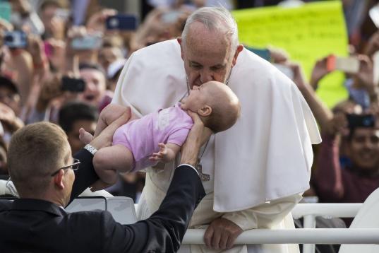 PHILADELPHIA, USA - SEPTEMBER 26: Pope Francis blesses a baby from the crowd with a kiss as he arrives at Independence Mall in Philadelphia, USA on September 26, 2015. (Photo by Samuel Corum/Anadolu Agency/Getty Images)