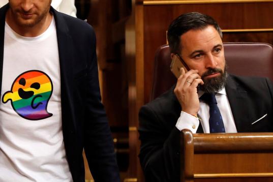 El socialista Arnau Ramírez pasa junto al líder de Vox, Santiago Abascal, con una camiseta de 'gaysper'.