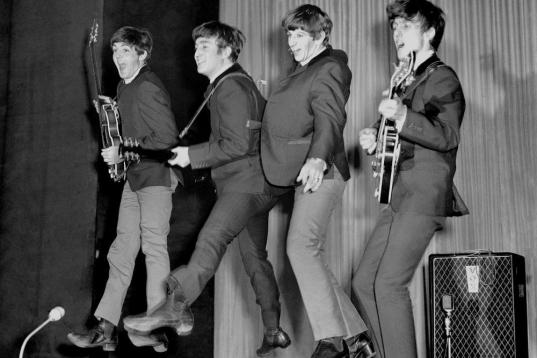 The Beatles jump to it on stage, left to right, Paul McCartney, John Lennon, Ringo Starr and George Harrison.