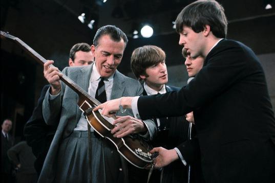 FILE - In this Feb. 9, 1964. file photo Paul McCartney, right, shows his bass guitar to Ed Sullivan before the Beatles' live television appearance on "The Ed Sullivan Show" in New York along with John Lennon, center, and Ringo Starr, behind McCa...
