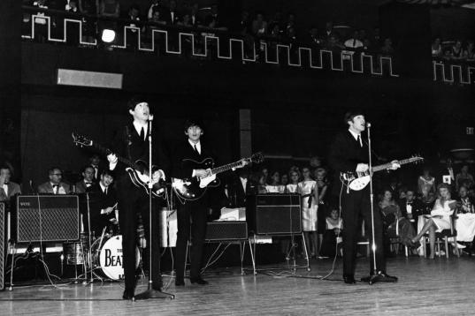 Pop group The Beatles, left to right Ringo Starr on drums, Paul McCartney, George Harrison and John Lennon on electric guitars, performing in a large dance hall during a Royal Variety performance in London, England on December 3, 1963. (Photo by...