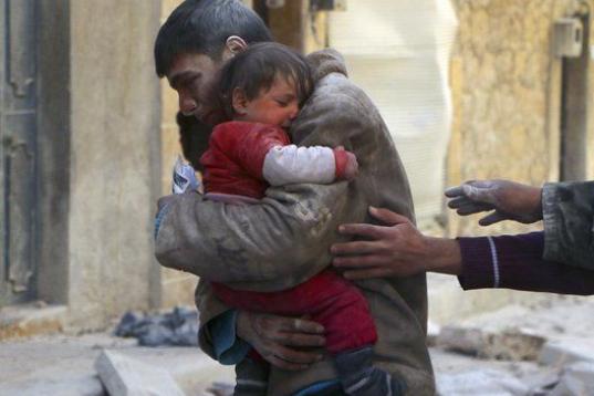 Un adolescente abraza a su pequeña hermana, recuperada de entre los escombros en la ciudad de Alepo, en febrero de 2014. Las tropas de El Asad atacaron la zona con bombas de barril, que consisten en un barril de petróleo, una bombona de gas o ...
