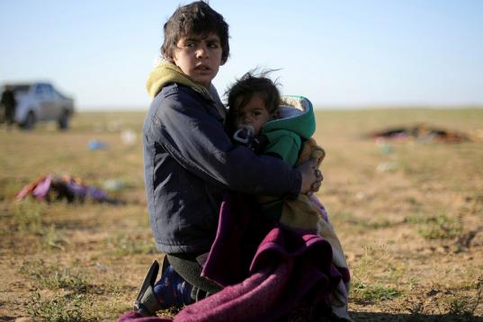Un niño cuida de su hermano tras escapar de Baghouz. 
