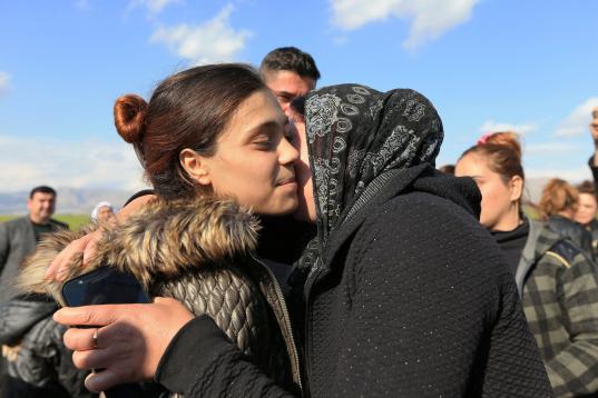 Unos familiares besan a una joven superviviente yazidí, tras la liberación de parte de su zona de manos del ISIS. 