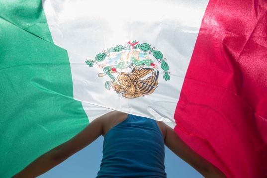 Kimberly Esparza protesta con una bandera mexicana por la llegada de Trump a Laredo, Texas. 

