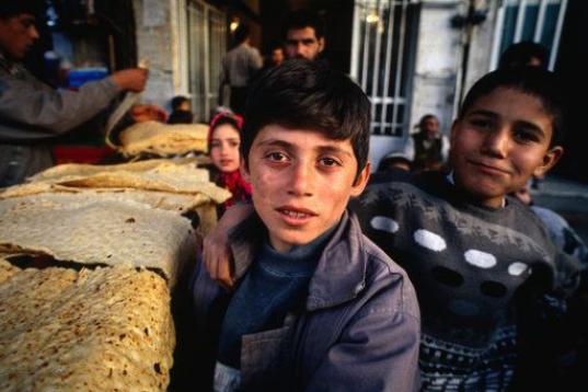 Niños en el campamento de refugiados ubicado Shiraz, Irán, recolectan pan para poder cenar.