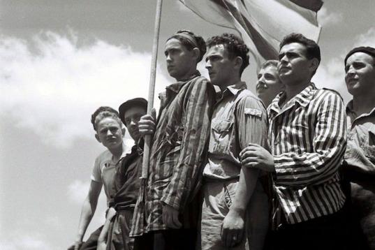 Supervivientes del campo de Buchenwald, algunos todavía con los uniformes de prisioneros, posan con orgullo en la cubierta del barco Mataroa, llegando al puerto de Haifa, durante el mandato británico de Palestina. Luego pasaría a ser parte de...