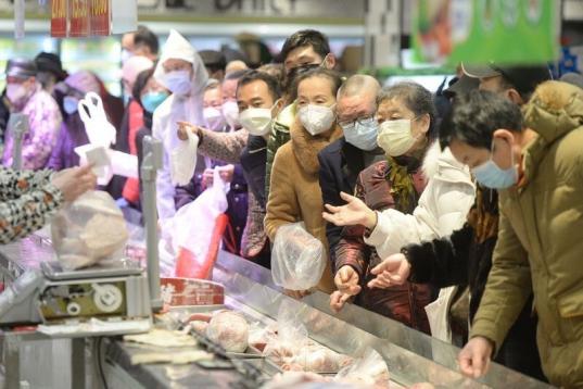 Clientes chinos hacen sus compras protegidos por mascarillas