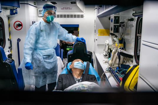Un sanitario atiende a un paciente en una ambulancia en Hong Kong