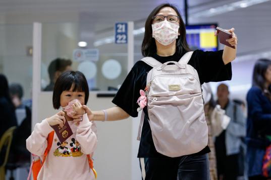Una mujer y su hija, con mascarillas en el aeropuerto de Manila (Filipinas)