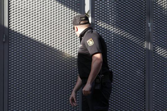 Un policía nacional cierra la puerta del garaje de la Audiencia Nacional tras la llegada de del extesorero del PP Luis Bárcenas hoy en un furgón de la Guardia Civil desde la prisión madrileña de Soto del Real.