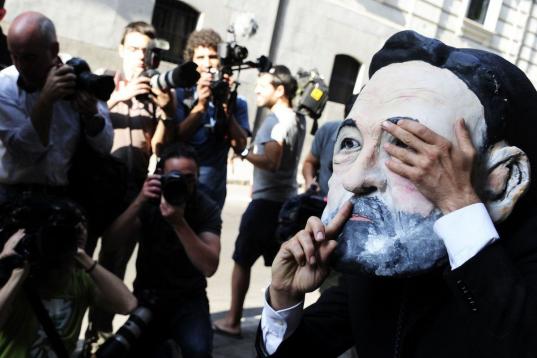 Un manifestante con una máscara de Mariano Rajoy espera a las puertas de la Audiencia Nacional.