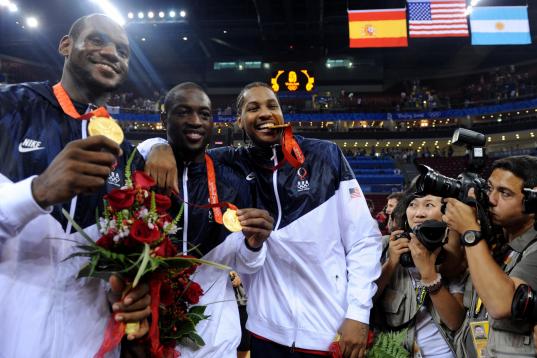 (HR) ABOVE: Carmelo Anthony, right, bites down on his medal with teammates Dwyane Wade, middle and Lebron James, left. The U.S. men's basketball team won the gold medal at the Beijing 2008 Olympic Games with a 118-107 victory over Spain Sunday a...