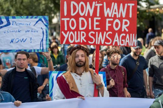 "No quiero volver a morir por vuestros pecados", dice la pancarta de este joven vestido de Jesucristo en Frankfurt. 