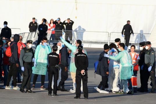 Miembros de la Cruz Roja, Policía Nacional y Guardia Civil dan la bienvenida y atienden a los primeros migrantes en España
