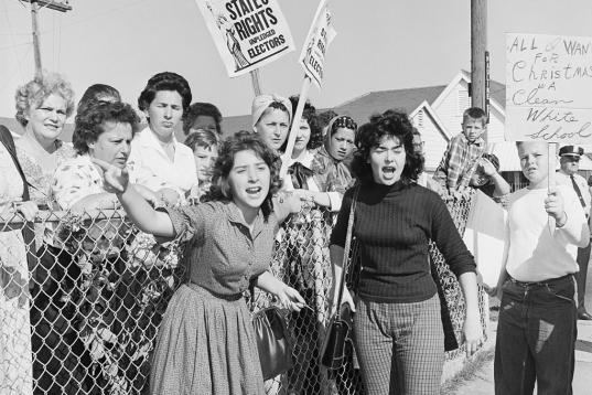 Un grupo de mujeres grita a la policía en 1961 durante una protesta contra la integración racial en las escuelas, con consignas como "salva la segregación" y "todo lo que quiero por Navidad es una escuela blan...