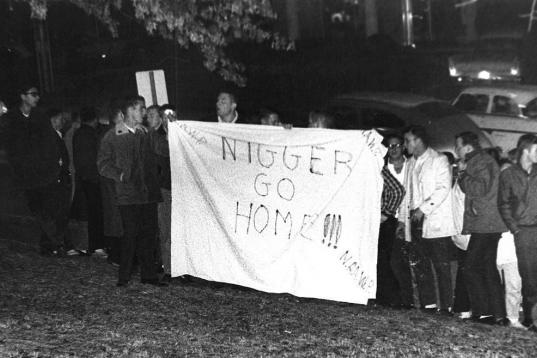 Un grupo de racistas protesta frente al dormitorio universitario de Charlayne Hunter, uno de los primeros estudiantes afroamericanos aceptado en la Universidad de Georgia en 1961. En el cartel se lee: "Negrata, vete a casa".
