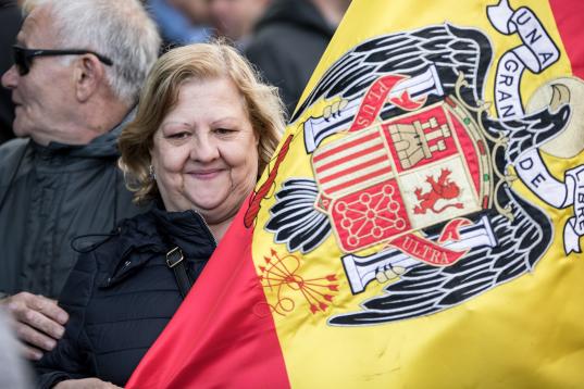 Una señora, con la bandera del águila, símbolo de la dictadura.