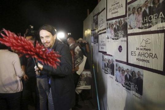 El secretario general de Podemos, Pablo Iglesias, durante la pegada de carteles con la que inició la campaña electoral en Madrid.