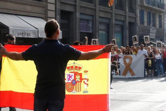 Un hombre con una bandera española frente a los manifestantes independentistas