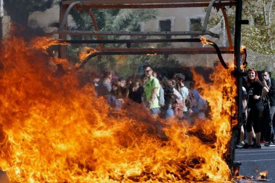 Un contenedor incendiado al término de la protesta en Valencia.