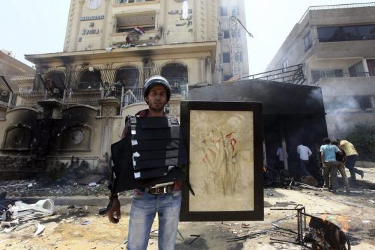Un egipcio viste un chaleco de seguridad presuntamente utilizado por miembros de los Hermanos Musulmanes e incautado en el asalto a la sede.
