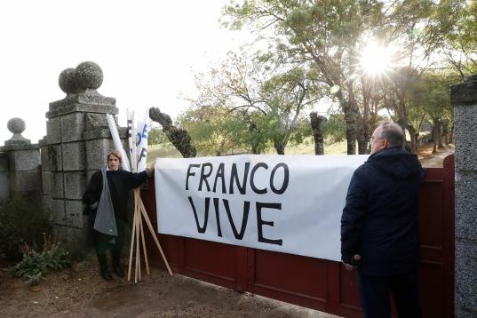  Varias personas despliegan una pancarta a favor del dictador a la entrada del Valle de los Caídos de donde serán exhumados los restos de Francisco Franco y trasladados al cementerio de El Pardo-Mingorrubio para su reinhumación.
