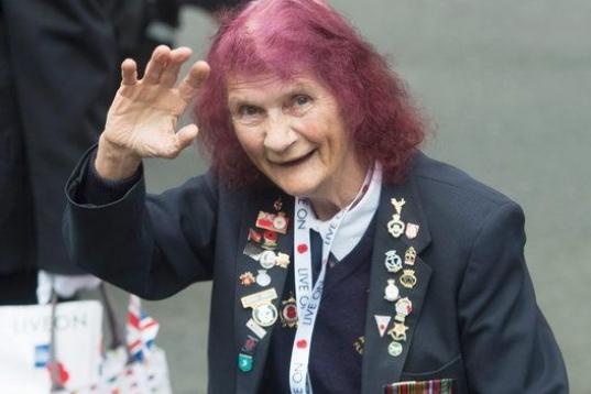 Una de las veteranas de la Segunda Guerra Mundial saluda a los fotógrafos en el acto celebrado en Londres. 