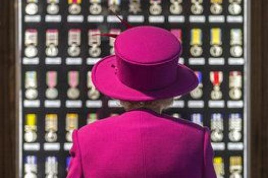 La reina Isabel II observa una vitrina con medallas durante su visita a unas dependencias del Ministerio de Defensa en Innsworth, Reino Unido.