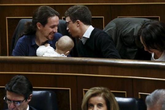Dos diputados de Podemos, Pablo Iglesias e íñigo Errejón, hacen carantoñas al bebé de su compañera, Carolina Bescansa.