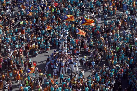 Un grupo de "castellers" actúan en la plaza de España de Barcelona durante la manifestación 