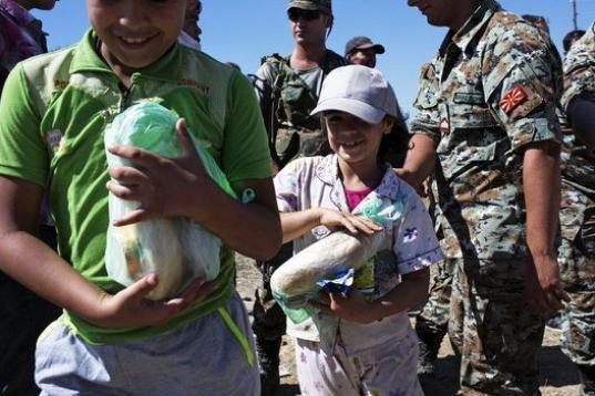 Varios niños refugiados reciben alimentos mientras cruzan la frontera entre Macedonia y Grecia, cerca del pueblo de Gevgelija, Macedonia. 