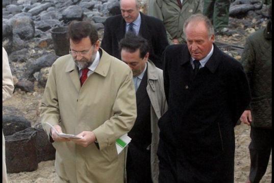 El rey Juan Carlos junto al entonces ministro Mariano Rajoy visitando las playas de Galicia. 