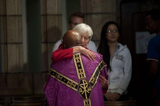 El arzobispo Desmond Tutu, de Cape Town (Sudáfrica) abraza a una feligresa al enterarse de la noticia