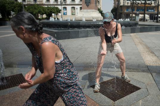 Dos mujeres intentan refrescarse en mitad de una plaza de Córdoba