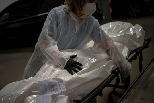 Marina Gómez, empleada de una funeraria, maneja el cadávez de una víctima del coronavirus en la morgue de su empresa, Mémora, en Barcelona, el 16 de noviembre de 2020. 