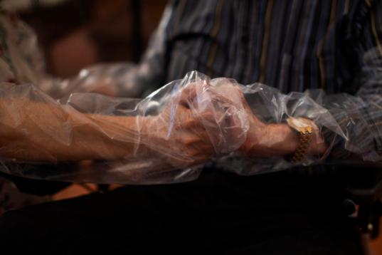 Dolores, de 61 años, sostiene las manos de su padre, José , de 87